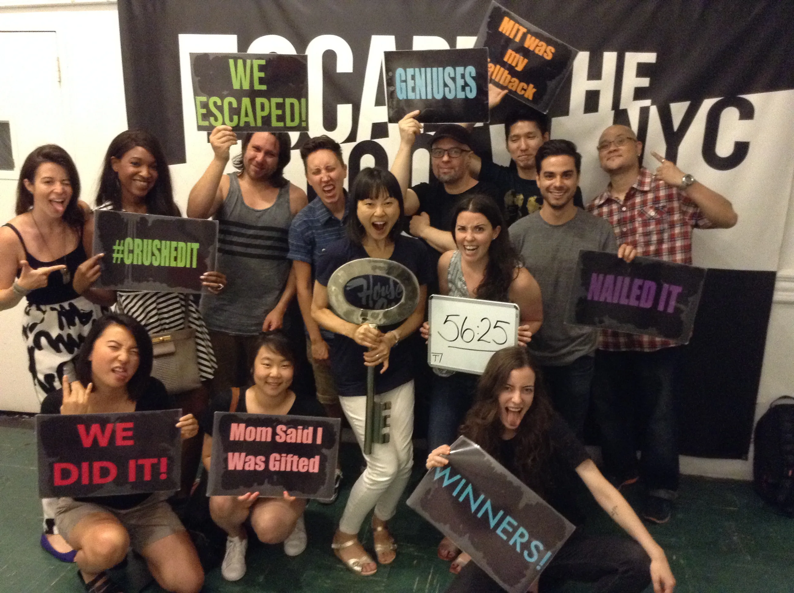Animoto team celebrating success at escape room with victory signs and achievement banners